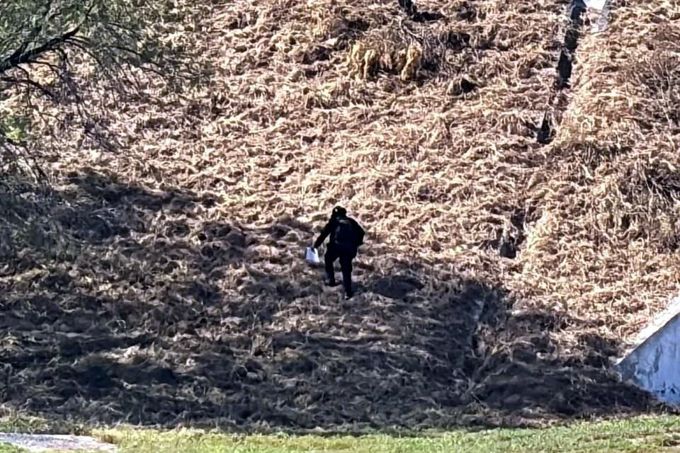 Tras un recorrido a pie por terrenos baldíos cercanos, los oficiales localizaron el cuerpo de un hombre con ropa táctica y un impacto de bala en el rostro.