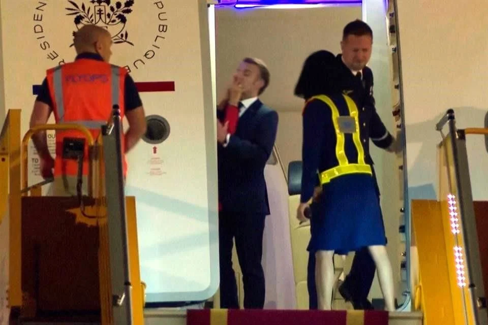 En las imágenes, Emmanuel Macron se adelanta hacia la salida del avión y gira hacia su esposa, quien, con un gesto aparentemente brusco, le empuja la cara con la mano.