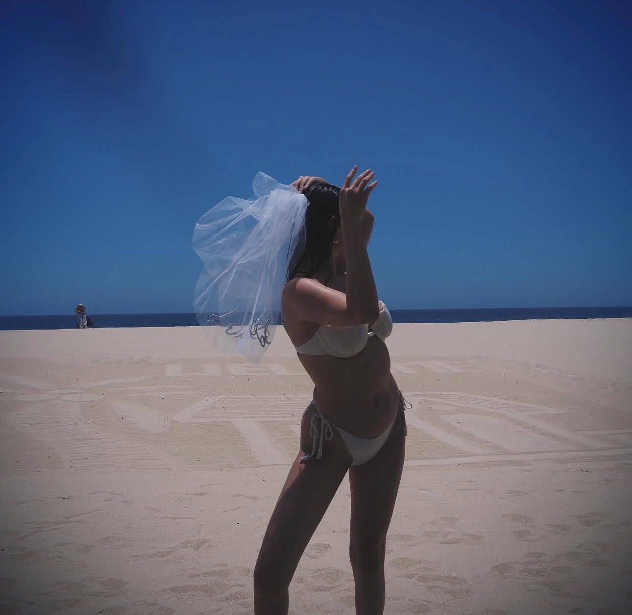 Durante la fiesta, Gómez sorprendió al lucir un vestido blanco adornado con perlas y un velo de novia, así como un bikini blanco para una sesión de fotos en la playa.