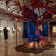La muestra propone un diálogo entre artes visuales y escénicas, con instalaciones inspiradas en la escenografía de la ópera, entre ellas una cama azul atravesada por un árbol rojo que simboliza elementos recurrentes en la obra de Kahlo