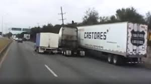 De acuerdo con el video, el conductor de un tráiler perteneciente a una empresa de paquetería intentó rebasar por el acotamiento de la carretera.