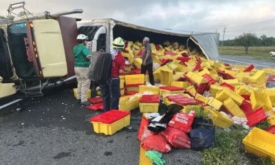 Tras el accidente, decenas de cajas con producto quedaron esparcidas sobre la carretera, situación que atrajo a automovilistas y personas que comenzaron a llevarse parte de la carga.